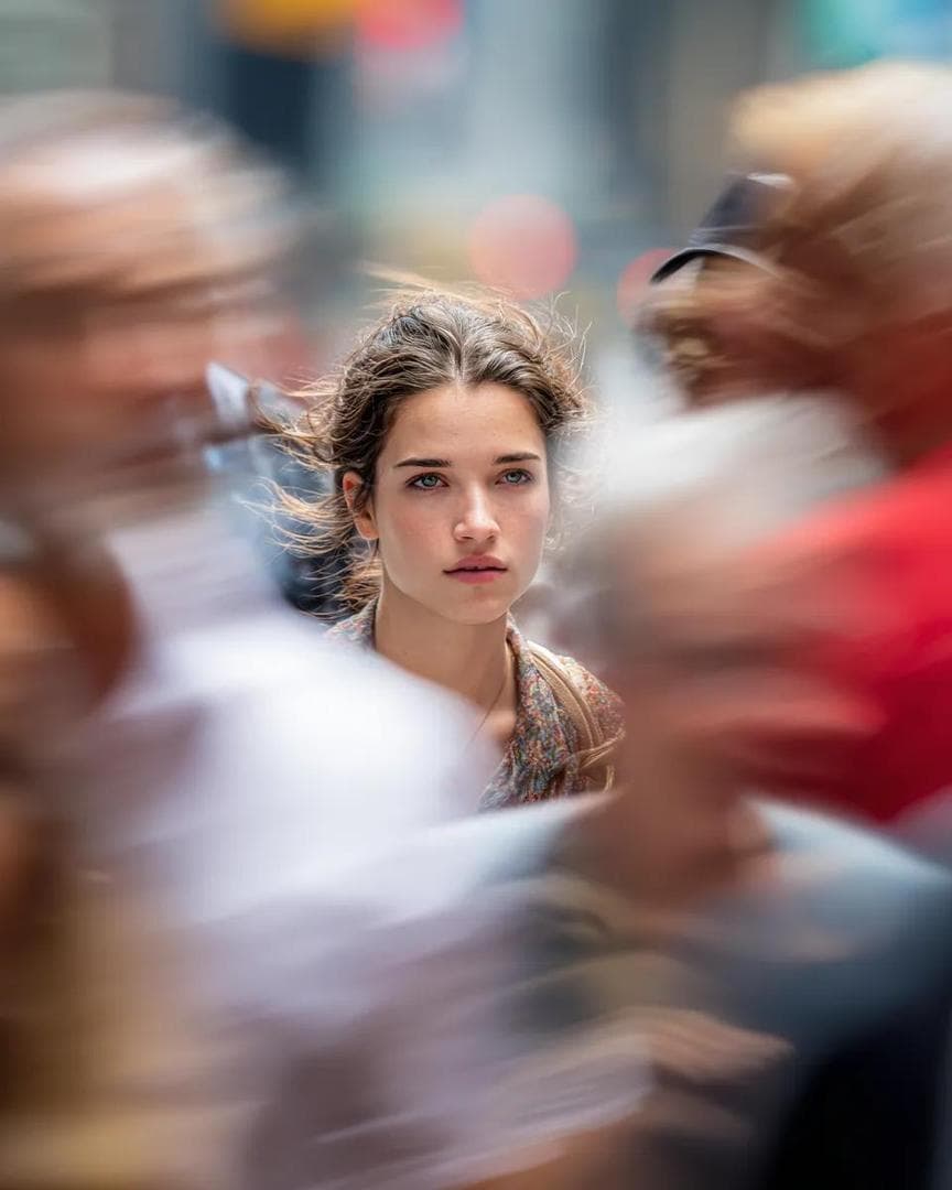 Model looking at camera, close up of face, busy New York street, motion blurred…