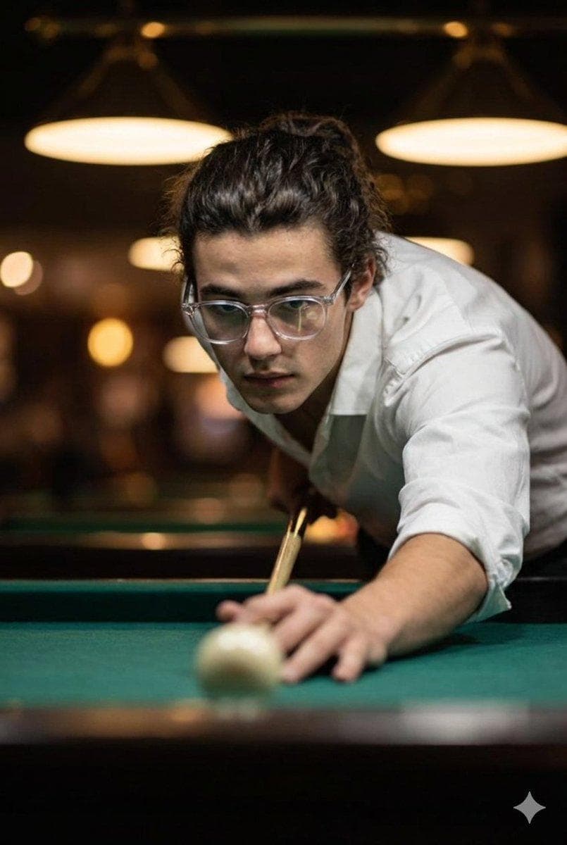 Cinematic ultra-realistic close-up of a man taking a billiards shot, captured in a tense, mid-focus moment as he leans low toward the cue ball. His eyes are locked sharply on the aim, expression steady and confident, while his supporting hand rests firmly on the green felt, guiding the cue with precision. He wears a crisp white shirt with rolled sleeves and slightly open buttons, giving a relaxed yet intensely focused vibe. His hair is neatly tied back, and his clear-framed…
