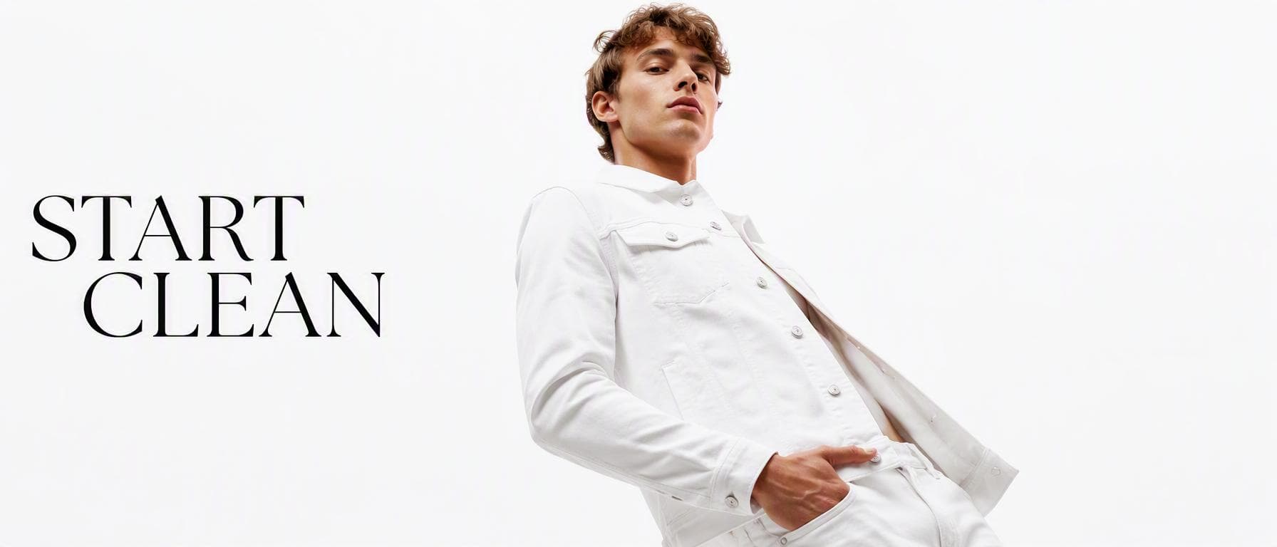 Luxury fashion photoshoot. Main Subject: Young male model wearing a bright white denim jacket. Pose: Leaning slightly backward with relaxed posture. Camera: Ultra-wide 20mm…