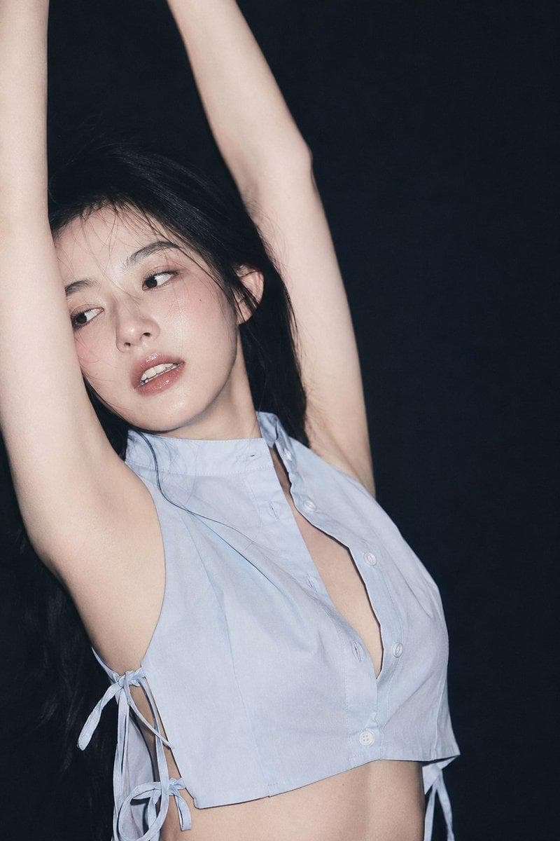 2:3,ccd直闪 90s 胶片杂志写真气质 近景半身裁切,人物占画面左中部与中央,人物2/3侧面视角,角色双臂上举形成纵深向框架(抬手拉伸),微侧头头部偏左,靠近左手臂。眼神湿润而游离,不直视镜头;眉眼放松但略带疲惫 and 疏离,微张唇,漏四齿。 中国女明星,清透脸部轮廓,半哑光冷白皮,真实皮肤微纹理,粉润腮红,自然卧蚕,低饱和裸粉唇,轻微湿润高光;黑色自然长发,少量碎发贴近额头和脸侧,发尾带一点空气感…