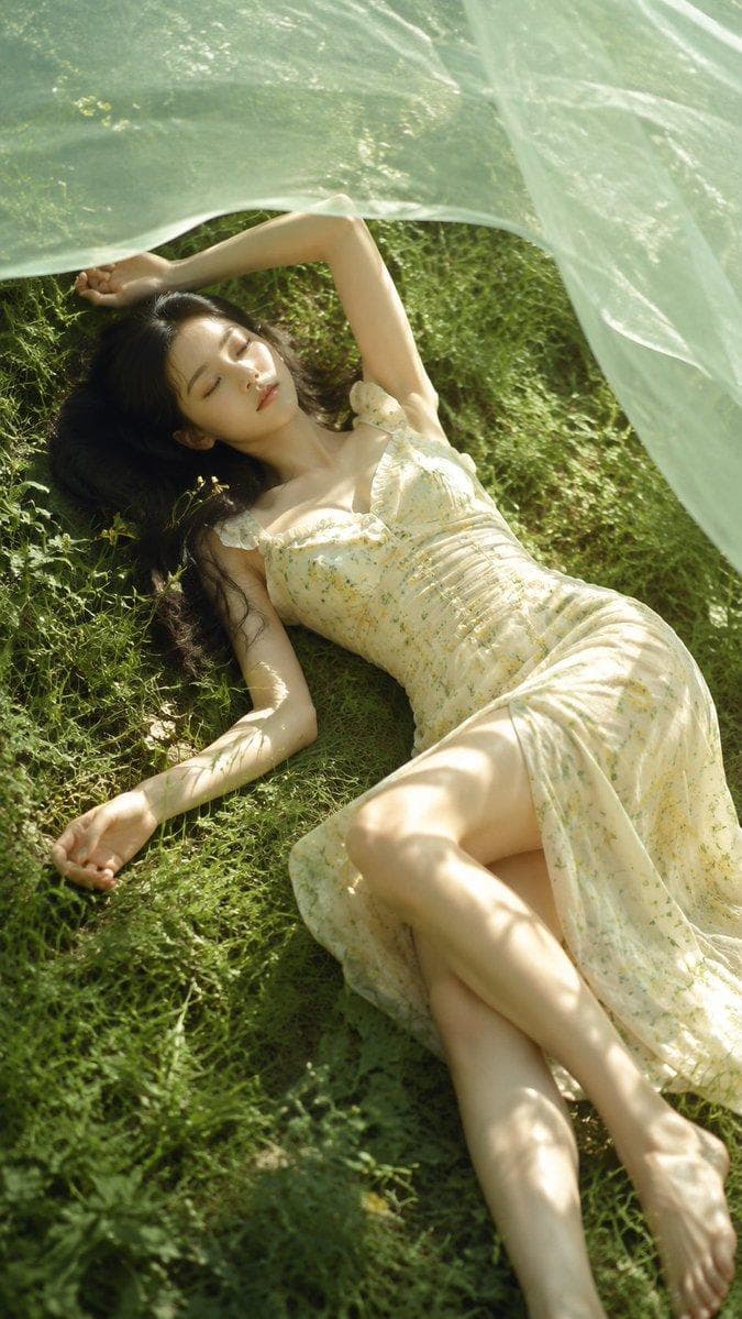A realistic outdoor natural-light portrait of an adult young woman lying on a summer grass field, fair natural skin tone, real skin texture, slim balanced body shape, soft feminine curves, relaxed pose, closed eyes, dreamy expression. She wears a light floral dress, white lace dress, or cream slip dress, with soft fabric folds and natural draping. A translucent sheer veil floats across the upper part of the frame, color options: soft green, creamy white, pale blue, or misty pink. Sunlight passes through the veil, creating soft dappled light on her face, shoulders, arms, dress, and the grass. Natural grass texture, subtle wildflowers, straw hat or wicker basket details, shallow depth of…